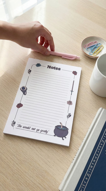 Lined ACOTAR-themed notepad with a cauldron, jurian eyeball ring, flowers, sword, and "she would not go gently."